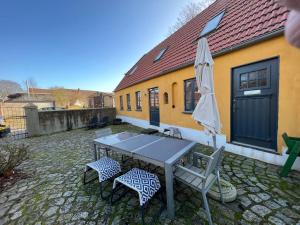 a patio with a table and two chairs and an umbrella at Historisches Pastorat - Villa Mika in Fehmarn