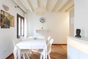a white dining room with a white table and chairs at Ca Francesca in Venice