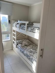 two bunk beds in a small room with a window at Cómodo apartamento en Torre Ocean Drive con todos los servicios in Punta del Este