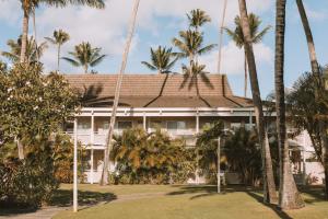 een gebouw met palmbomen ervoor bij Plantation Hale Suites in Kapaa