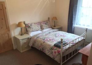 a bedroom with a bed and two lamps and a window at 4 Bedroom House For Corporate Stays in Kettering in Isham