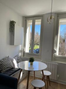 ein Wohnzimmer mit Tisch und Couch in der Unterkunft L'Appartement Bleu - Logement cosy - Cœur de ville in Douai