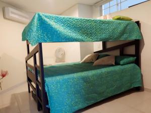 a bedroom with a bunk bed with a green sheet at Apartamento Frente al Mar in Santa Marta +33 photos