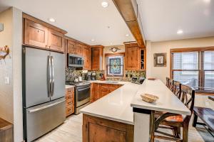 a kitchen with wooden cabinets and a stainless steel refrigerator at Wendall Square Condo Great Breck Location in Breckenridge +24 photos