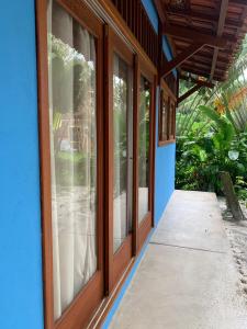 eine Tür zu einem Haus mit Fenstern in der Unterkunft Chalés Cumuruxatiba in Cumuruxatiba