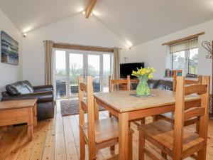 a living room with a wooden table and chairs at Vine Cottage in Saint Ewe
