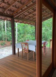 a pavilion with a table and chairs on a deck at Chalés Cumuruxatiba in Cumuruxatiba