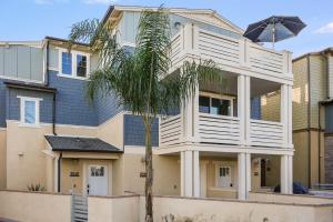 a house with a palm tree in front of it at Bayside Cove Estate in San Diego