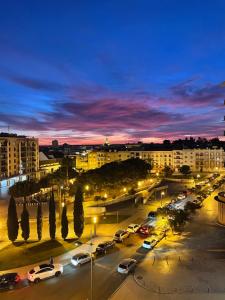una città con auto parcheggiate in un parcheggio di notte di Villa Infante a Huelva