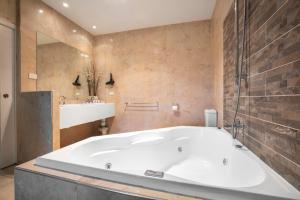 a bathroom with a large tub and a sink at Nightcap at Macquarie Inn in Dubbo +56 photos