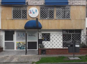 a building with a blue awning in front of it at Hotel COMIC CITY in Bogotá