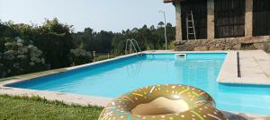 a large inflatable donut laying next to a swimming pool at Casa de Penim in Paredes de Coura