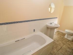 een badkamer met een bad, een toilet en een wastafel bij No 3 Low Hall Cottages in Scalby +2 foto's