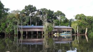 a house on the water with a boat in it at Reserva Yavary Tucano in Leticia +33 photos