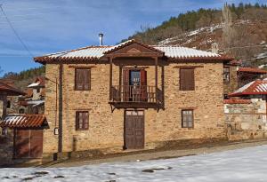 a brick house with a balcony on the front at Lithia s Stonehouse. Το πέτρινο στη Λιθιά - Καστοριά in Lithiá