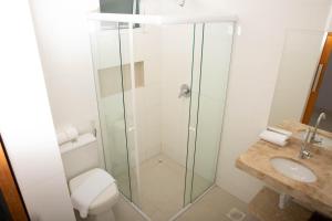 a bathroom with a shower and a toilet and a sink at Hotel Araguaia in Palmas