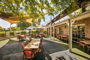 an outdoor patio with tables and chairs and a building at Nightcap at Macquarie Inn in Dubbo
