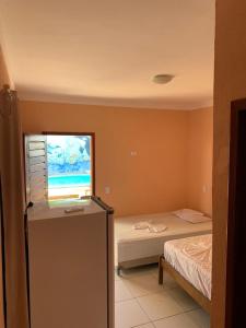 Habitación pequeña con cama y ventana en Chalé do Aldo, en Canoa Quebrada