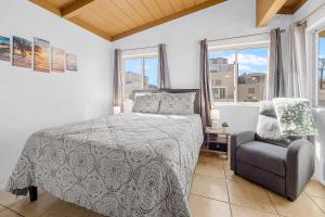 聖地牙哥的住宿－甜美日落一室公寓，一间卧室配有一张床、一把椅子和窗户。