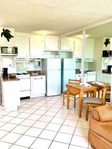 a kitchen with white appliances and a table and chairs at Coastal Cozy - Ocean View at Symphony Beach Club in Ormond Beach