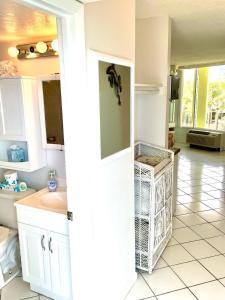 a white bathroom with a sink and a toilet at Coastal Cozy - Ocean View at Symphony Beach Club in Ormond Beach