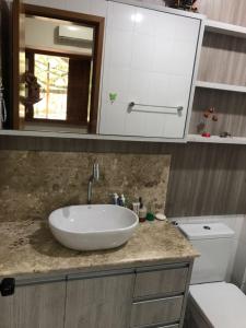 une salle de bain avec un lavabo blanc et des toilettes dans l'établissement O paraíso na terra tem nome: Praia do Forte, à Praia do Forte