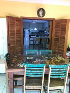 une table de salle à manger avec des chaises et une cuisine dans l'établissement O paraíso na terra tem nome: Praia do Forte, à Praia do Forte 3 autres photos