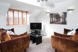 a living room with two chairs and a tv at 8 Eureka Mews in Plawsworth