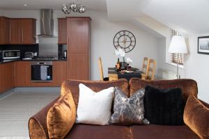 a living room with a brown couch with pillows at 8 Eureka Mews in Plawsworth