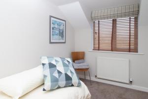 a bedroom with a bed and a window and a chair at 8 Eureka Mews in Plawsworth