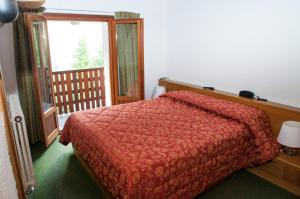 A bed or beds in a room at Hotel Vallée De Cogne