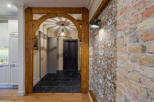 a hallway with a brick wall and an archway at Dzirnavu Residence 2 bedroom Apartment in Rīga