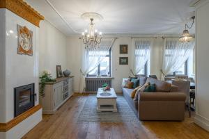 ein Wohnzimmer mit einem Sofa und einem TV in der Unterkunft Dzirnavu Residence 2 bedroom Apartment in Riga