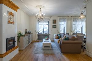 a living room with a couch and a tv at Dzirnavu Residence 2 bedroom Apartment in Riga