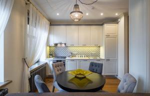 a kitchen with a table and chairs and a table and a kitchen at Dzirnavu Residence 2 bedroom Apartment in Riga