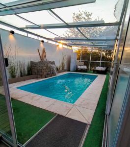 una piscina con pérgola en una casa en Altos del Pucará Piscina Climatizada Juegos infantiles Huerta Orgánica en Huerta Grande