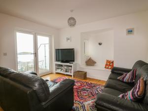 a living room with a couch and a television at Fistral Outlook in Crantock