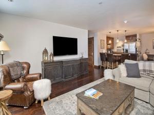 a living room with a flat screen tv on a wall at Ascent Condo 111 in Avon