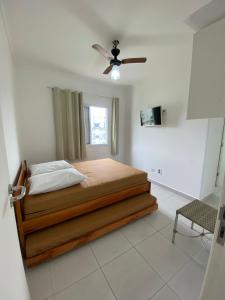 Schlafzimmer mit einem Bett und einem Deckenventilator in der Unterkunft Apartamento com excelente localização e conforto! in Ubatuba