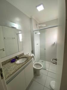 ein Bad mit einem WC, einem Waschbecken und einer Dusche in der Unterkunft Apartamento com excelente localização e conforto! in Ubatuba
