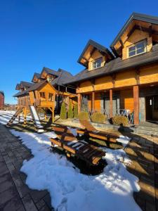 a log home in the winter with snow on the ground at Mountain Villa Zlatibor in Zlatibor