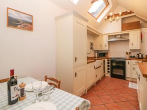 een keuken met een tafel en een fles wijn bij Hawthorn Cottage in Eyam