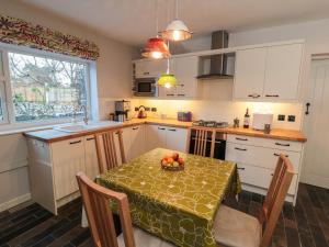 - une cuisine avec une table et un bol de fruits dans l'établissement Jasmine Cottage, à Bakewell