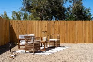 2 chaises et une table en face d'une clôture dans l'établissement Red Rock - Desert feel - Game Room, à Joshua Tree