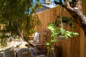 un patio con una silla y plantas colgando de una valla en Red Rock - Desert feel - Game Room, en Joshua Tree