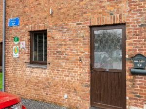 a brick building with a wooden door and a window at Gite in Lessive close to Rochefort in Rochefort