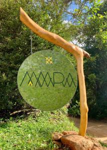 a sign that says mrw on a tree branch at Projeto MAARA in Nova Friburgo