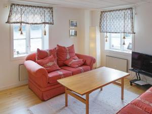 ein Wohnzimmer mit einem roten Sofa und einem Tisch in der Unterkunft Holiday home ÅSBRO II in Åsbro