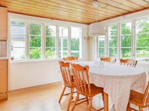 a dining room with a white table and chairs at Holiday home ÅSBRO II in Åsbro