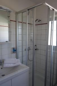 een badkamer met een douche en een wastafel bij Hotel Gästehaus Linden in Wolfenbüttel
